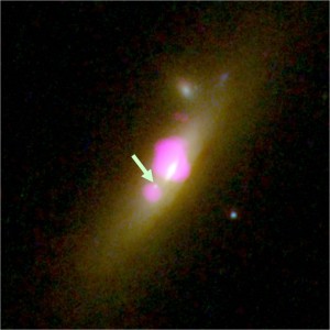 Hubble (background) and Chandra (purple) image of SDSS J1126+2944. The arrow marks the second black hole. (From http://casa.colorado.edu/~comerford/press)