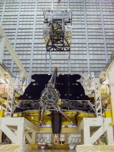 A nerve-wracking moment wherein JWST science instruments are lifted by crane above the mirror, and both are suspended face-down over the clean-room floor, as the observatory is assembled. [NASA/Chris Gunn]