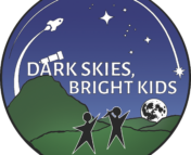This image says "Dark Skies, Bright Kids" in all caps, white letters. The "A" in "Dark" is also a telescope at the top of a mountain. The image has green mountains with a rising moon in the background. There are several stars in the sky, along with a shooting star and rocket framing the image. There are two silhouettes of children standing at the foot of the mountain pointing up at the sky. The children are abstractly drawn, and almost appear to be stars.