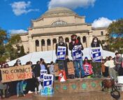 Students on strike in front of Columbia's iconic Low Library. Holding blue signs for UAW and a large cardboard sign saying "No Contract No Work"