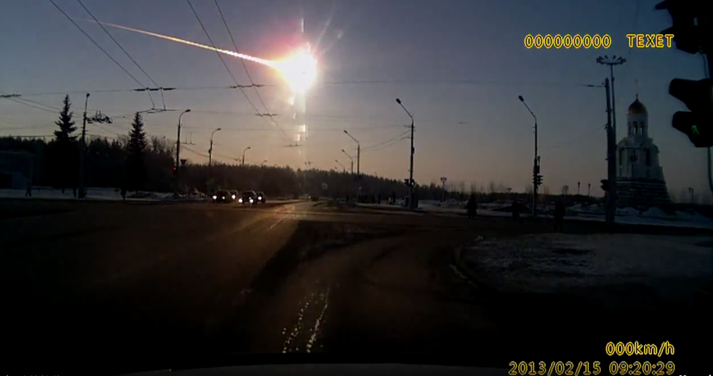 A still frame from a dash cam recording of the Celyabinsk meteor. The meteor shines very bright and its flaming tail is visible.