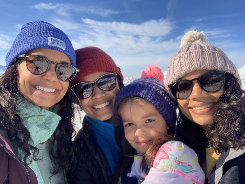 Dr. Patel smiling with her sisters and niece