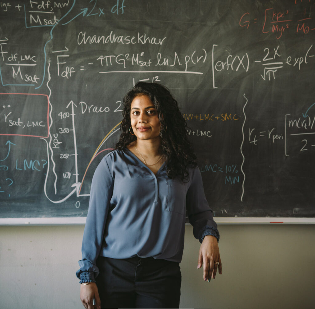 Dr. Ekta Patel standing in front of a blackboard