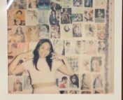 Polaroid of Teresa Panurach posed with peace signs in front of a collaged wall.