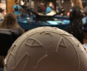 A 3D printed half dome with a planetarium projector in the background