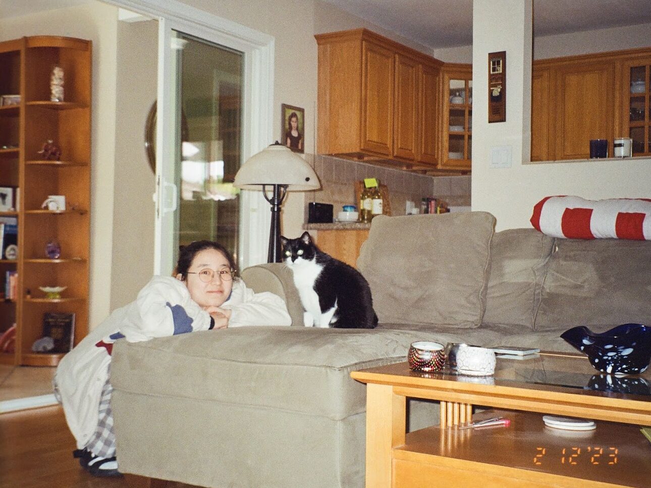 photo of the author of this post next to a black and white cat on a couch