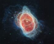 Colored JWST MIRI image of the Southern Ring Nebula. An elliptical red bubble surrounds the star at the center of the nebula. A light blue shell contours out the bubble, with various protuberances extending into the dark space around the nebula