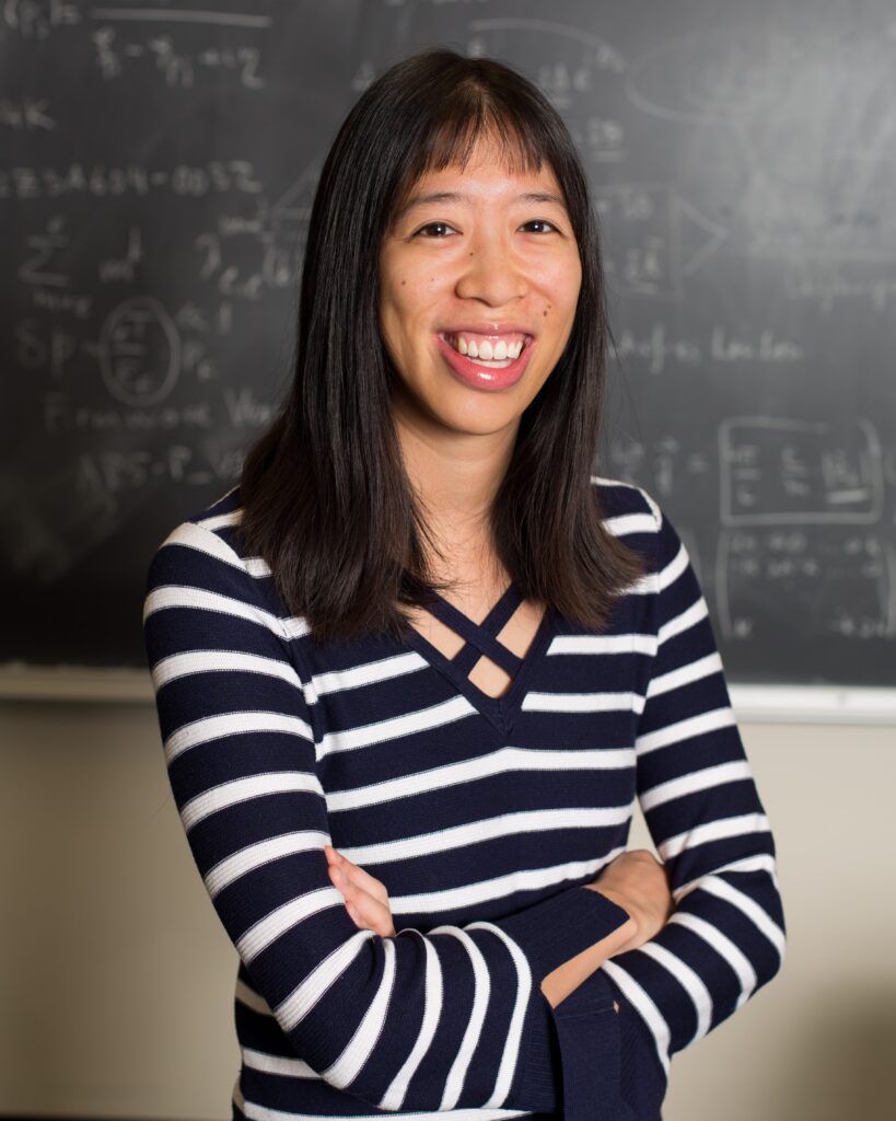 Photo of Dr. Wen-fai Fong, who is standing in front of a chalkboard and smiling widely at the camera