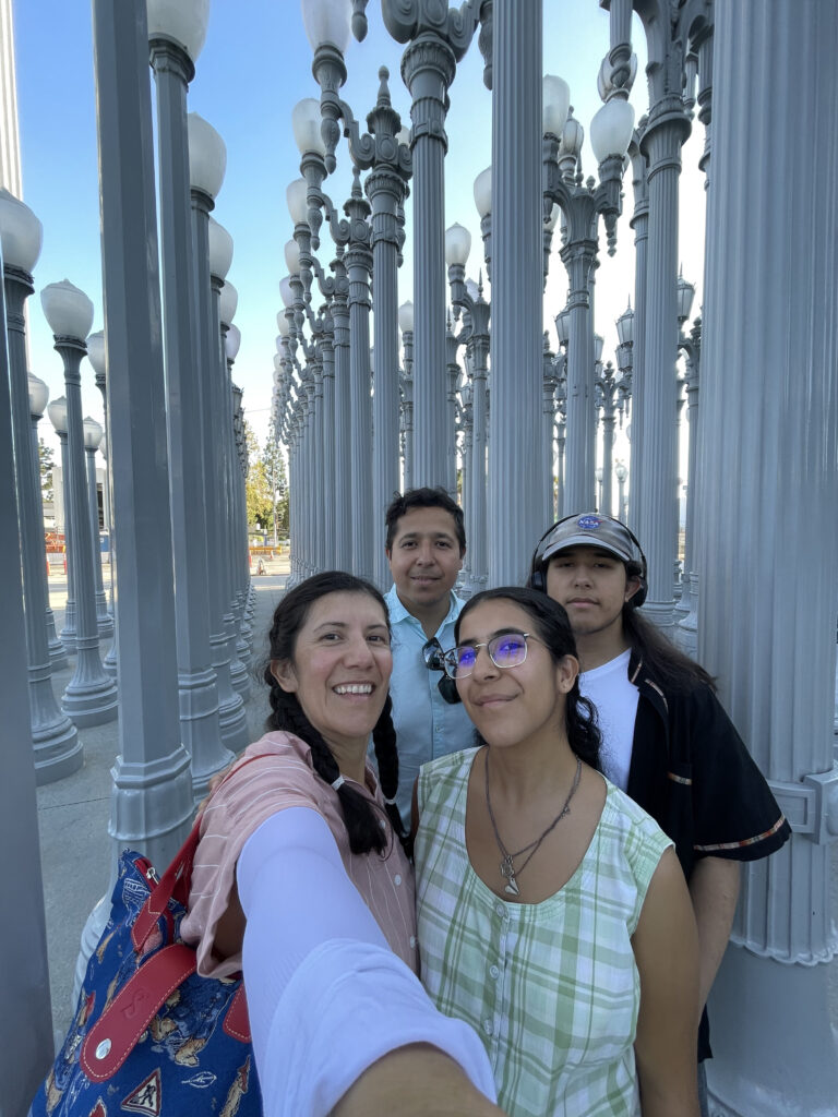 A selfie of four people standing among lanterns