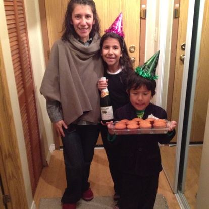 A woman and two children wearing party hats