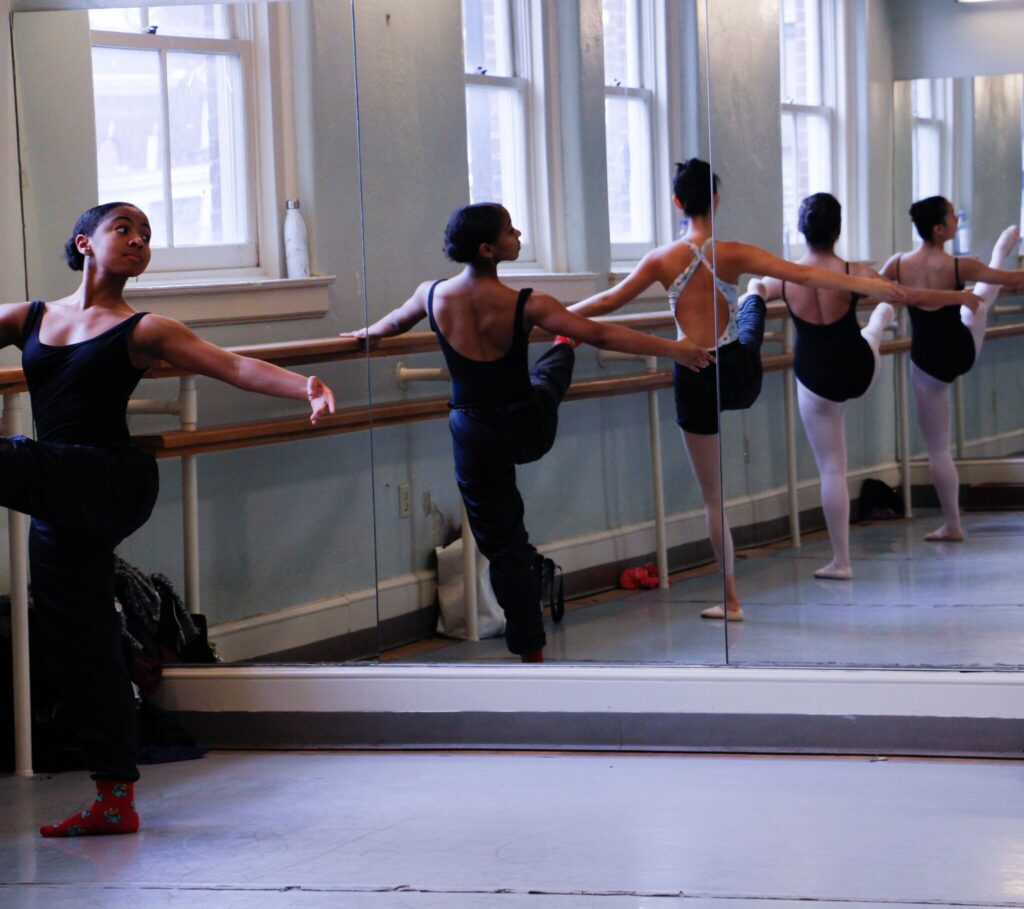 Ballet dancers stretching on a bar