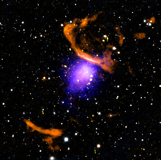 A composite image of the galaxy cluster PLCK G287.0+32.9 shown in radio and X-ray emission is displayed. The X-ray signal shines strongest in a central spherical region, while the radio is offset and in the form of two large arcs.