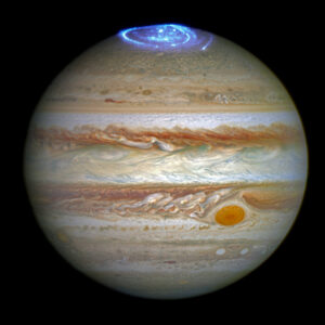 A image of jupiter in color. The north pole of jupiter shows its aurora colored in blue.